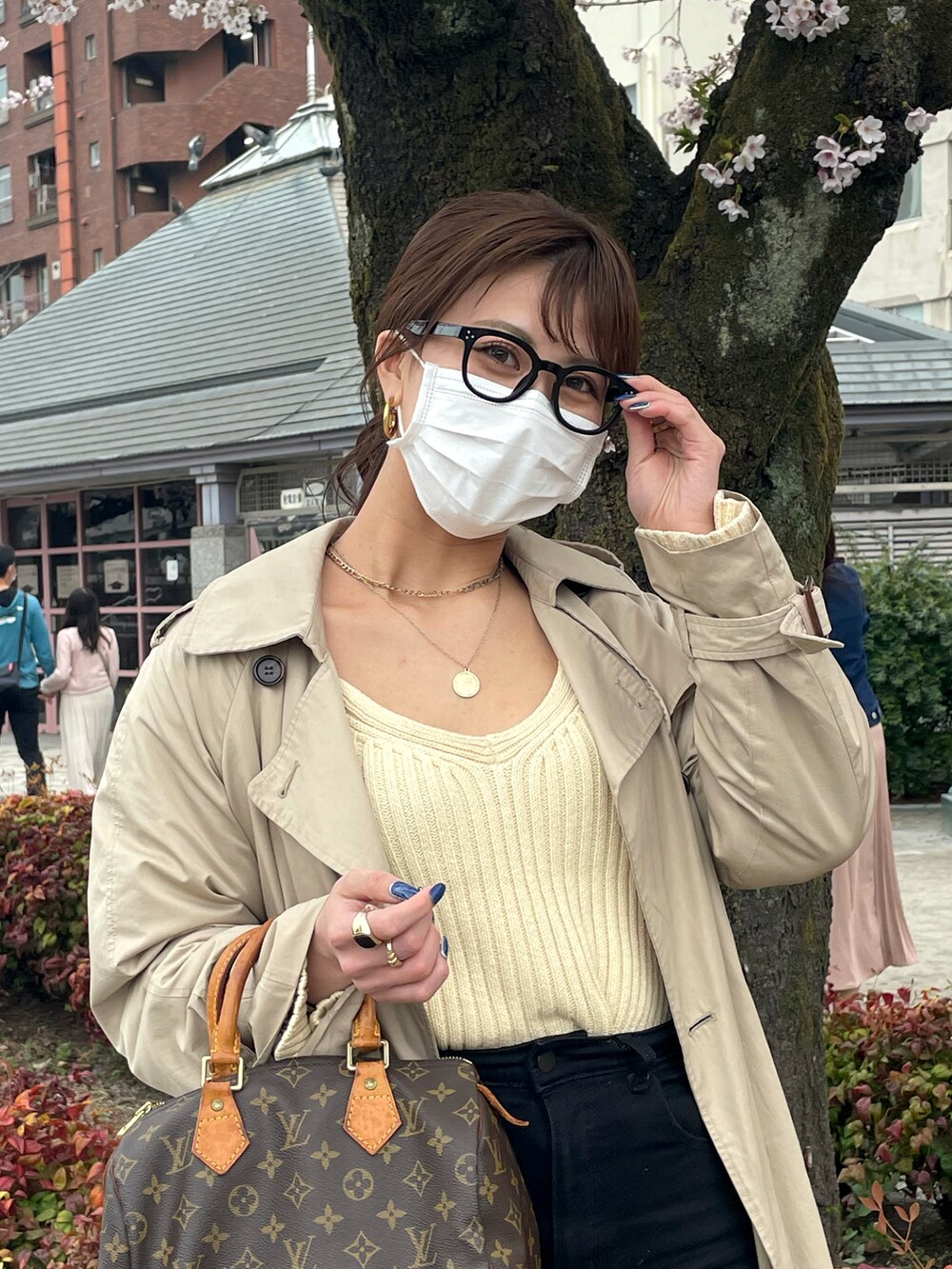 ベージュ系のカーディガン/ボレロ、ブラック系のデニムパンツ、ベージュ系のトレンチコートを着用したレディースの春コーディネートの2枚目の写真