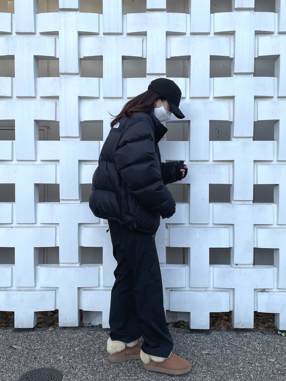 ブラック系のダウンジャケット/コート、ブラック系のスラックス、ブラウン系のブーツを着用したレディースの冬コーディネートの2枚目の写真