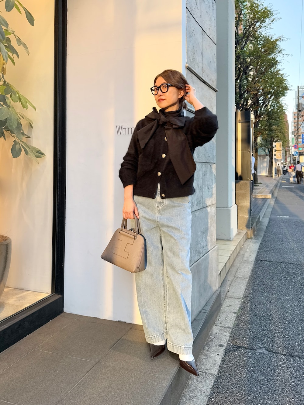 ブラック系のカーディガン/ボレロ、ブラック系のシャツ/ブラウス、ブルー系のデニムパンツを着用したレディースの秋コーディネートの4枚目の写真