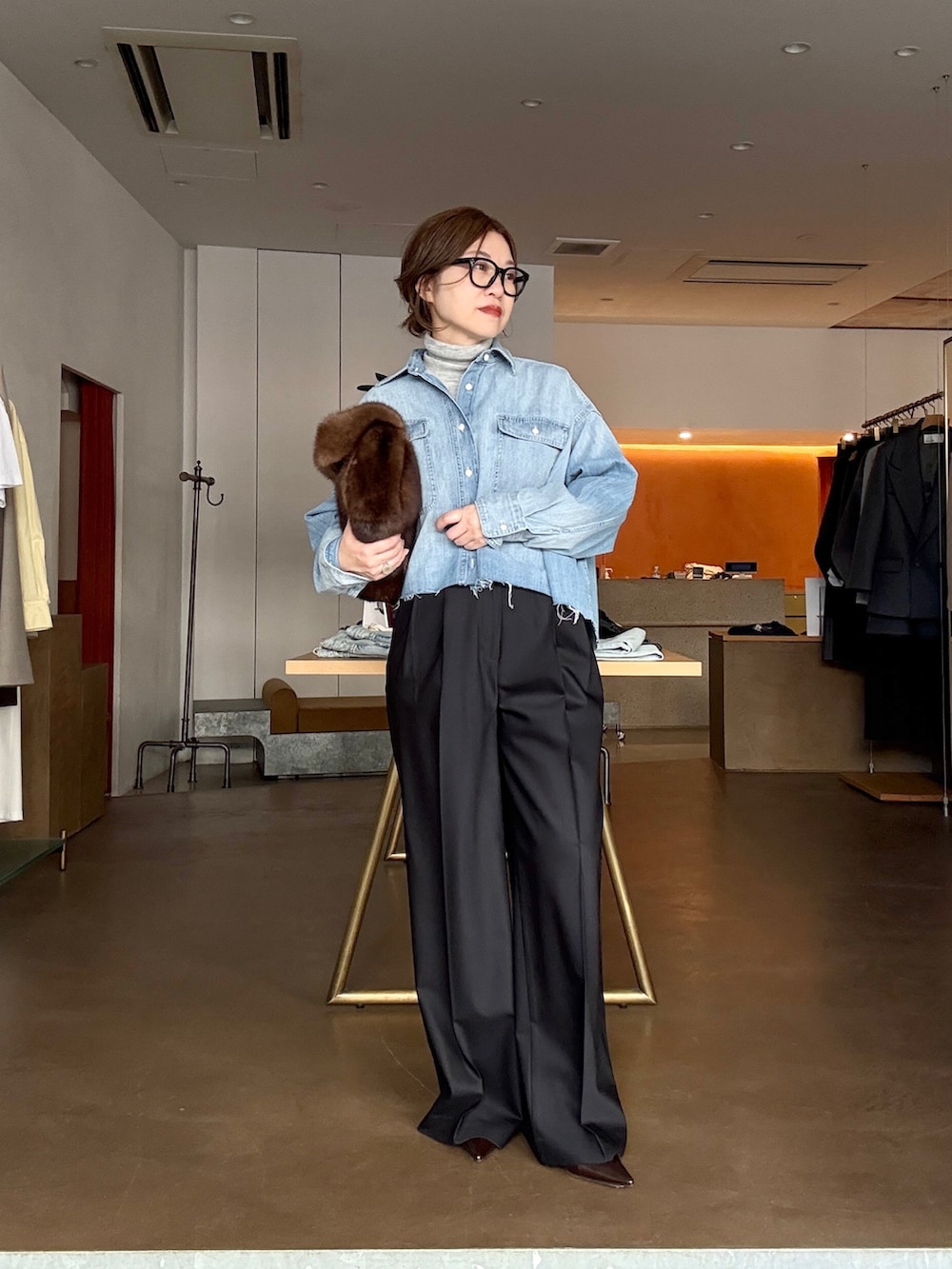 ブルー系のシャツ/ブラウス、ブルー系のスラックス、ブラウン系のパンプスを着用したレディースの冬コーディネートの2枚目の写真