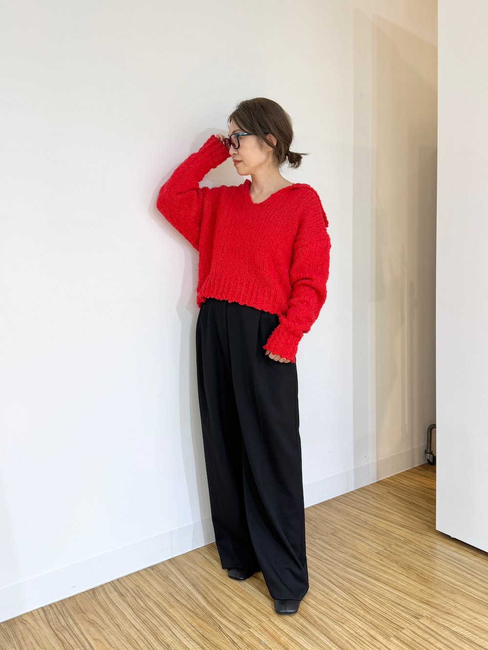 レッド系のニット/セーター、ブラック系のその他パンツを着用したレディースの秋コーディネートの3枚目の写真