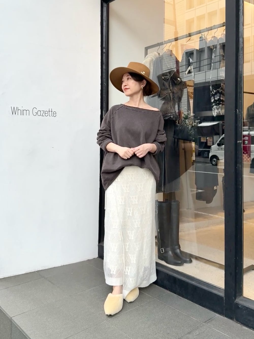 ブラウン系のスウェット、ホワイト系のスカート、ベージュ系のサンダルを着用したレディースの秋コーディネートの3枚目の写真