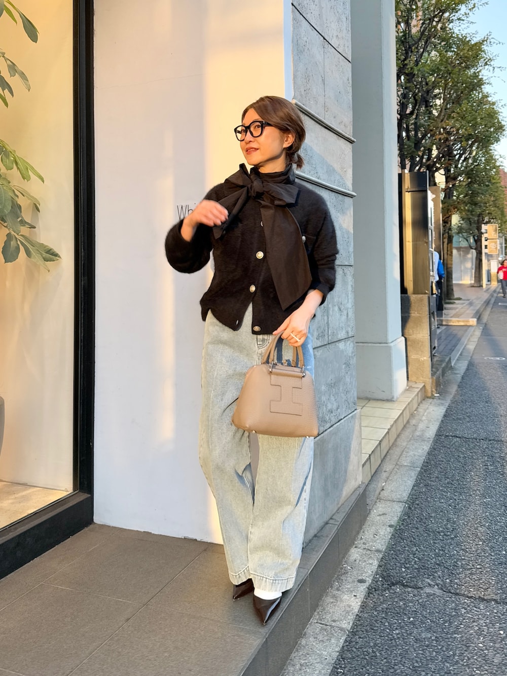 ブラック系のカーディガン/ボレロ、ブラック系のシャツ/ブラウス、ブルー系のデニムパンツを着用したレディースの秋コーディネートの2枚目の写真