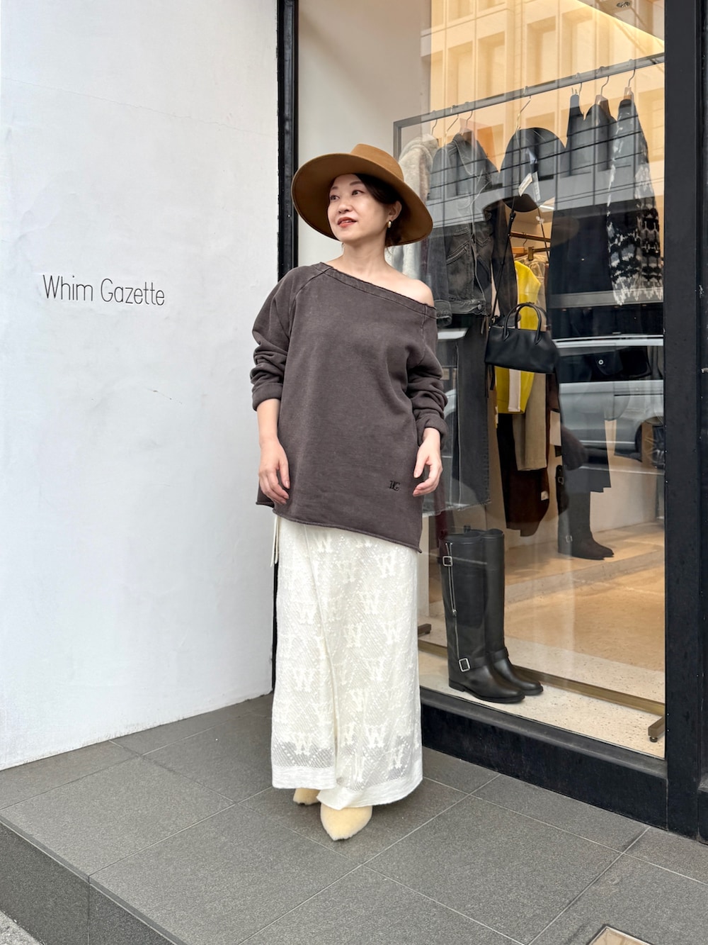 ブラウン系のスウェット、ホワイト系のスカート、ベージュ系のサンダルを着用したレディースの秋コーディネートの4枚目の写真