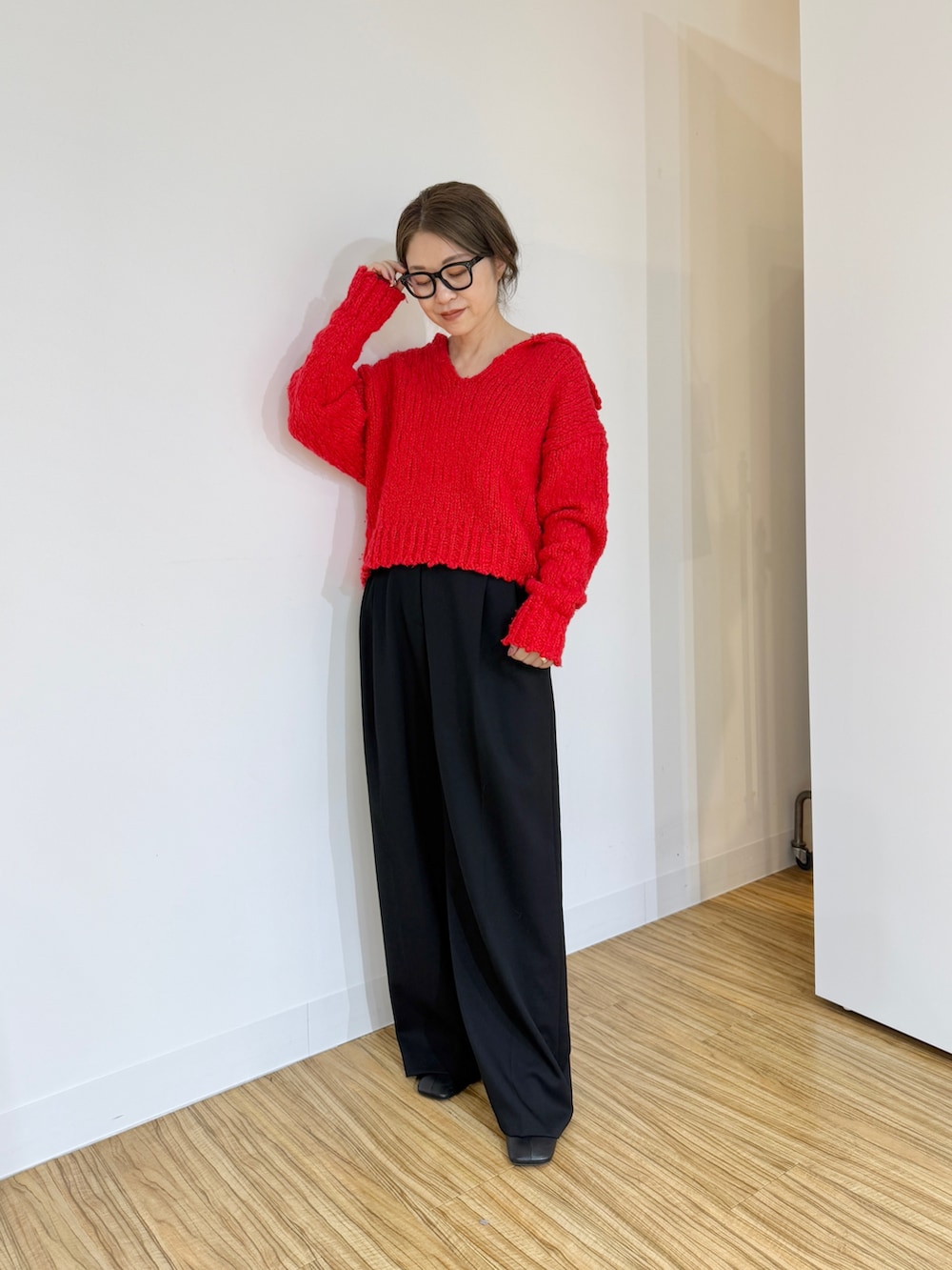 レッド系のニット/セーター、ブラック系のその他パンツを着用したレディースの秋コーディネートの2枚目の写真