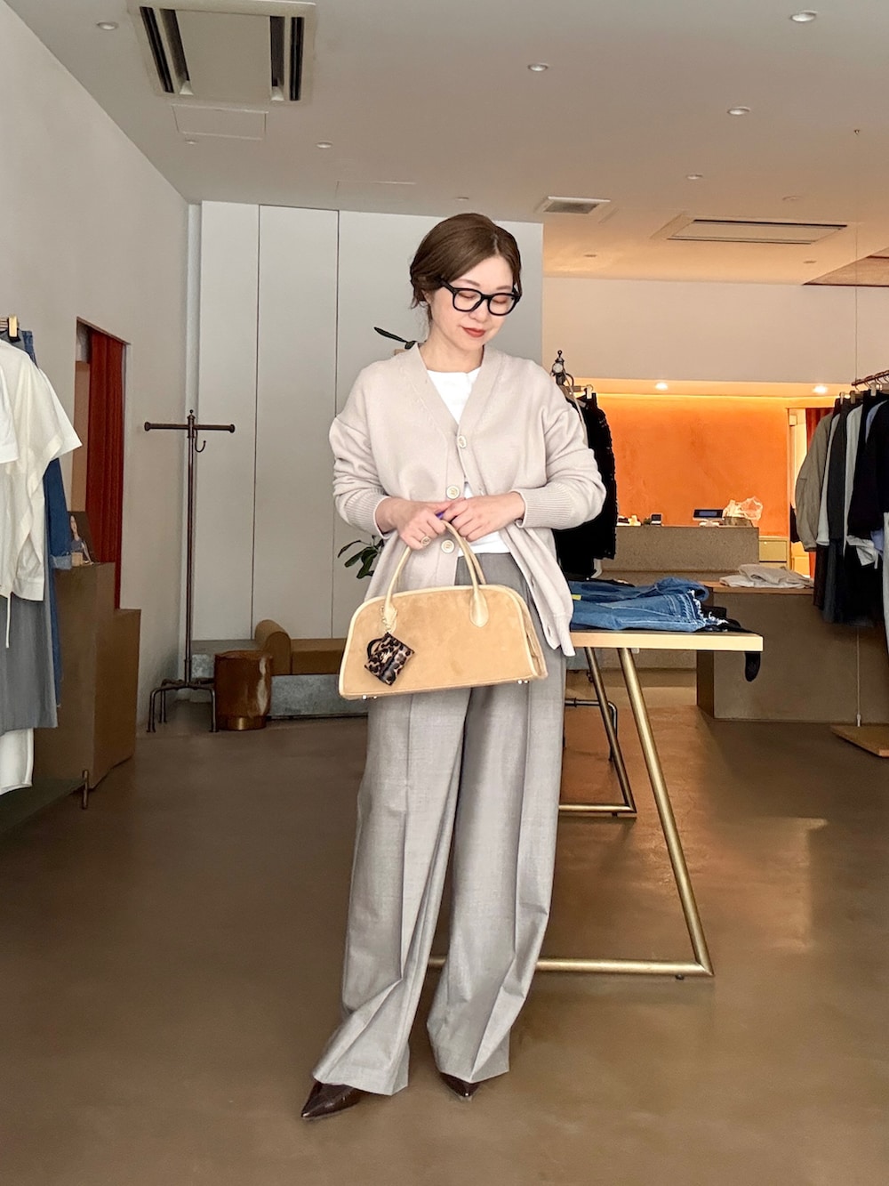 ベージュ系のカーディガン/ボレロ、ホワイト系のTシャツ/カットソー、ブラウン系のスラックスを着用したレディースの冬コーディネートの6枚目の写真