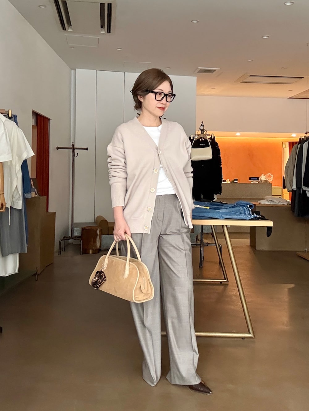 ベージュ系のカーディガン/ボレロ、ホワイト系のTシャツ/カットソー、ブラウン系のスラックスを着用したレディースの冬コーディネートの4枚目の写真