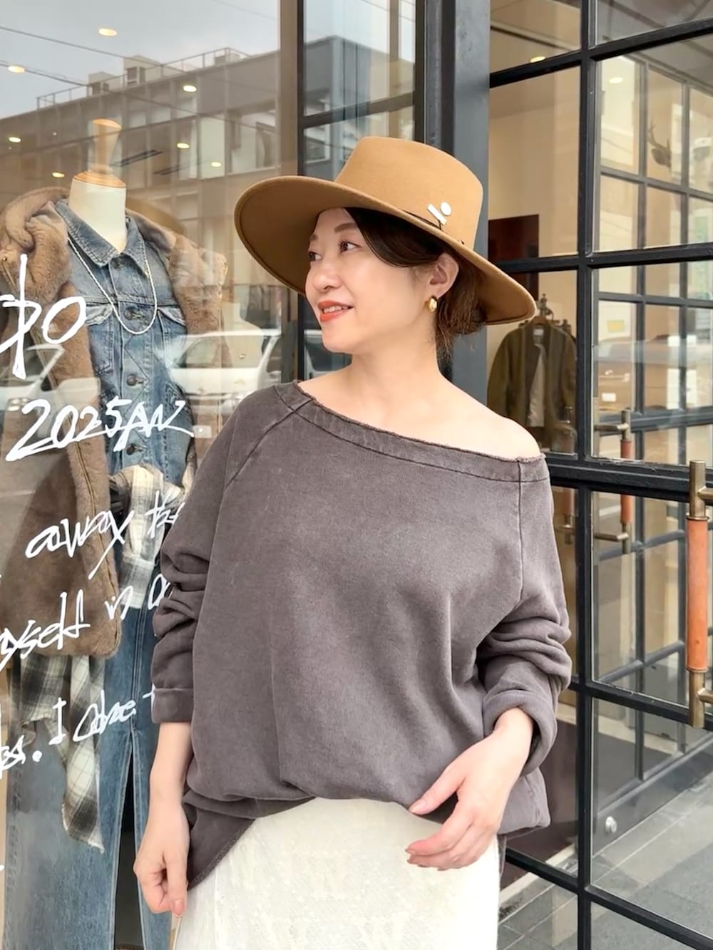 ブラウン系のスウェット、ホワイト系のスカート、ベージュ系のサンダルを着用したレディースの秋コーディネートの2枚目の写真