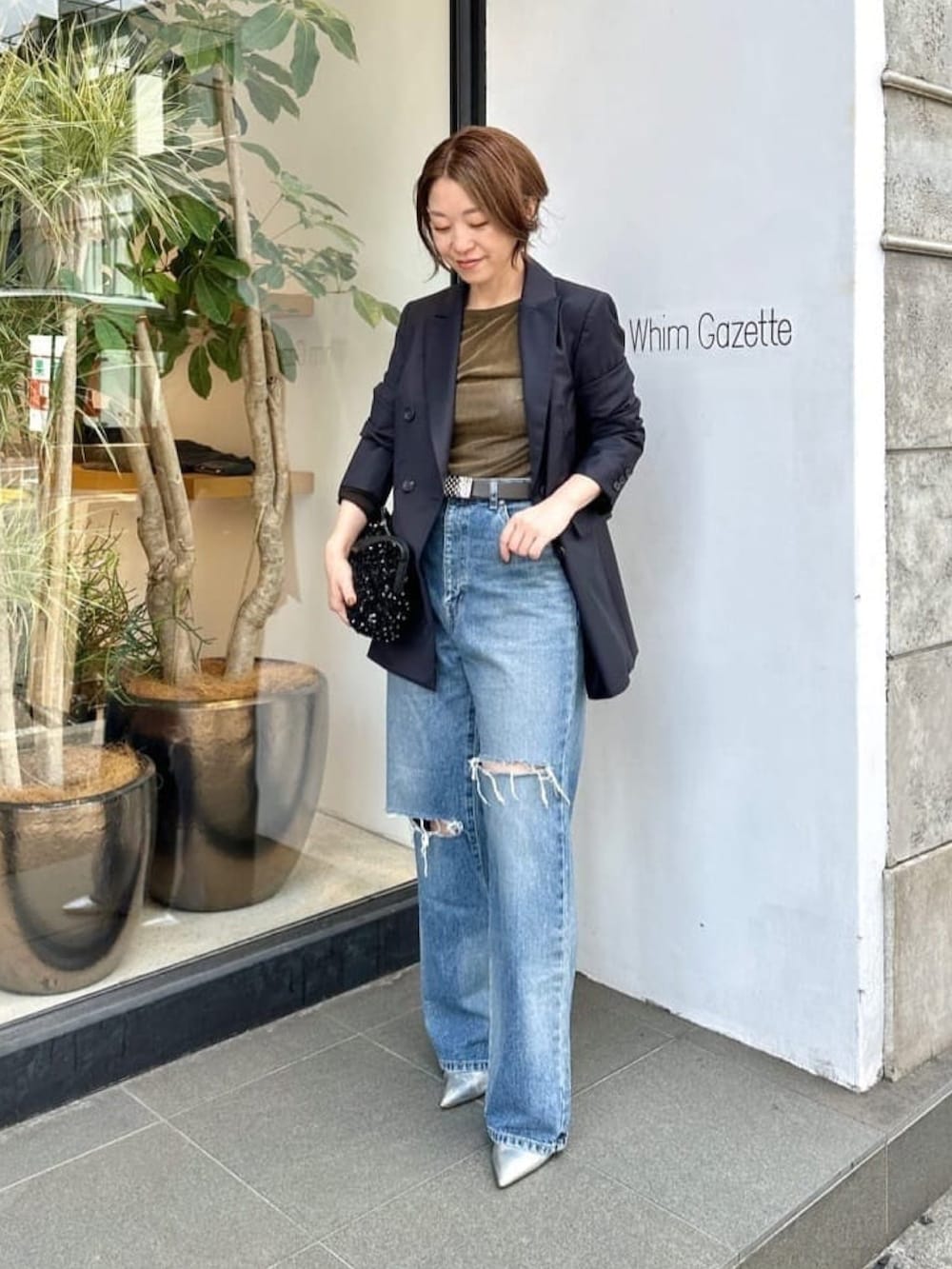 グリーン系のTシャツ/カットソー、ブルー系のテーラードジャケット、ブルー系のデニムパンツを着用したレディースの冬コーディネートの3枚目の写真