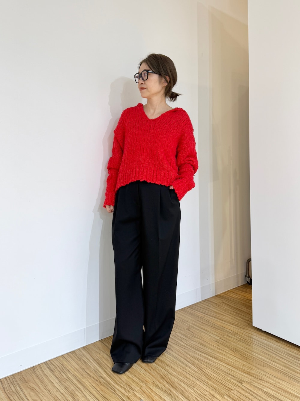 レッド系のニット/セーター、ブラック系のその他パンツを着用したレディースの秋コーディネートの4枚目の写真