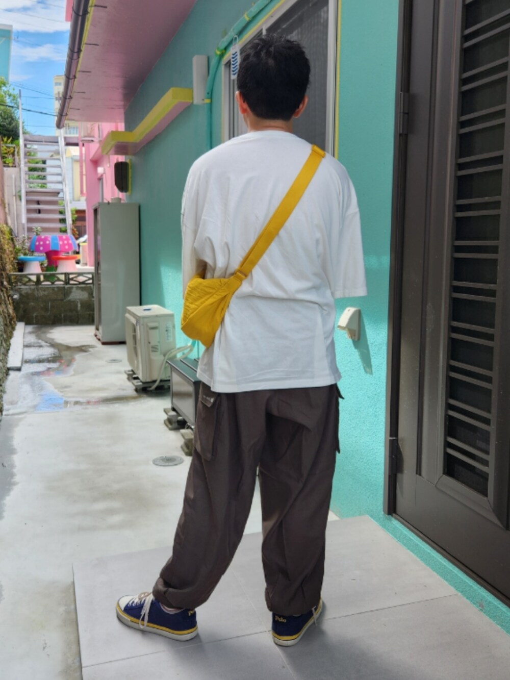 ブルー系のスニーカー、グリーン系のカーゴパンツ、ホワイト系のTシャツ/カットソーを着用したメンズの秋コーディネートの2枚目の写真