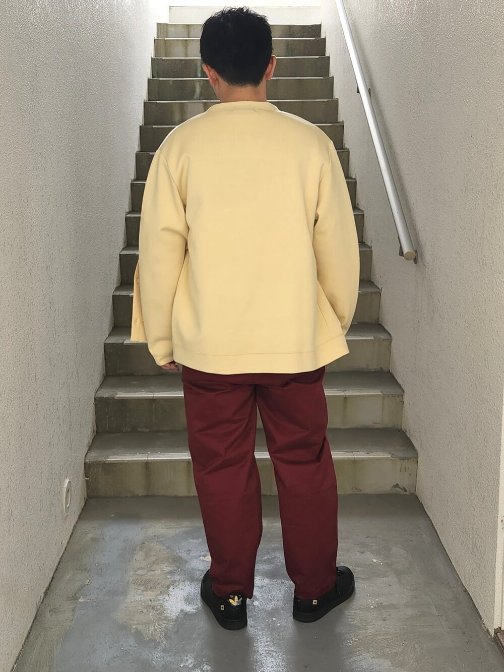 グリーン系のTシャツ/カットソー、ベージュ系のカーディガン/ボレロ、ブラック系のスニーカーを着用したメンズの秋コーディネートの2枚目の写真