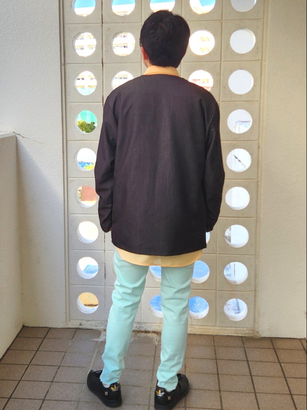 グリーン系のその他パンツ、ブラック系のノーカラージャケット、オレンジ系のシャツ/ブラウスを着用したメンズの春コーディネートの2枚目の写真