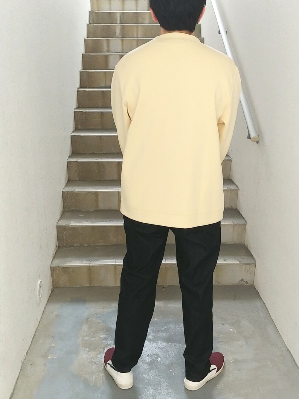 ブルー系のデニムパンツ、レッド系のスリッポン、ベージュ系のカーディガン/ボレロを着用したメンズの春コーディネートの2枚目の写真