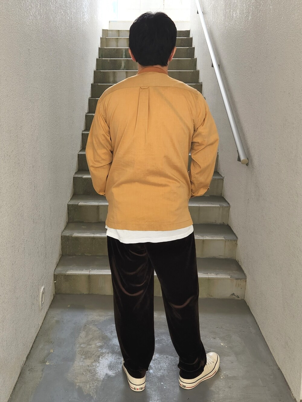 ブラウン系のその他パンツ、ホワイト系のTシャツ/カットソー、イエロー系のブルゾンを着用したメンズの秋コーディネートの2枚目の写真