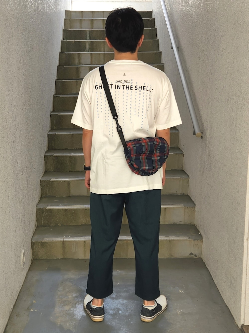 ホワイト系のスリッポン、グリーン系のスラックス、ホワイト系のTシャツ/カットソーを着用したメンズの夏コーディネートの2枚目の写真
