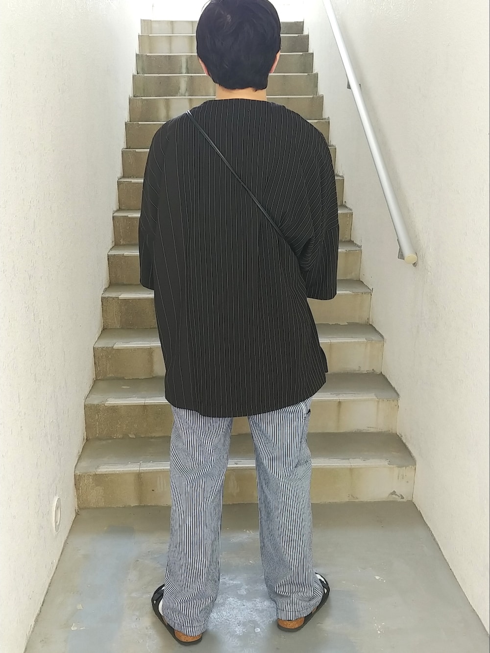 ブラック系のサンダル、ブルー系のその他パンツ、ブラック系のTシャツ/カットソーを着用したメンズの春コーディネートの2枚目の写真