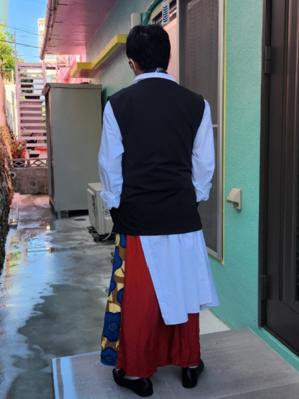 ブラック系のベスト、ホワイト系のワンピース、レッド系のその他パンツを着用したメンズの冬コーディネートの2枚目の写真