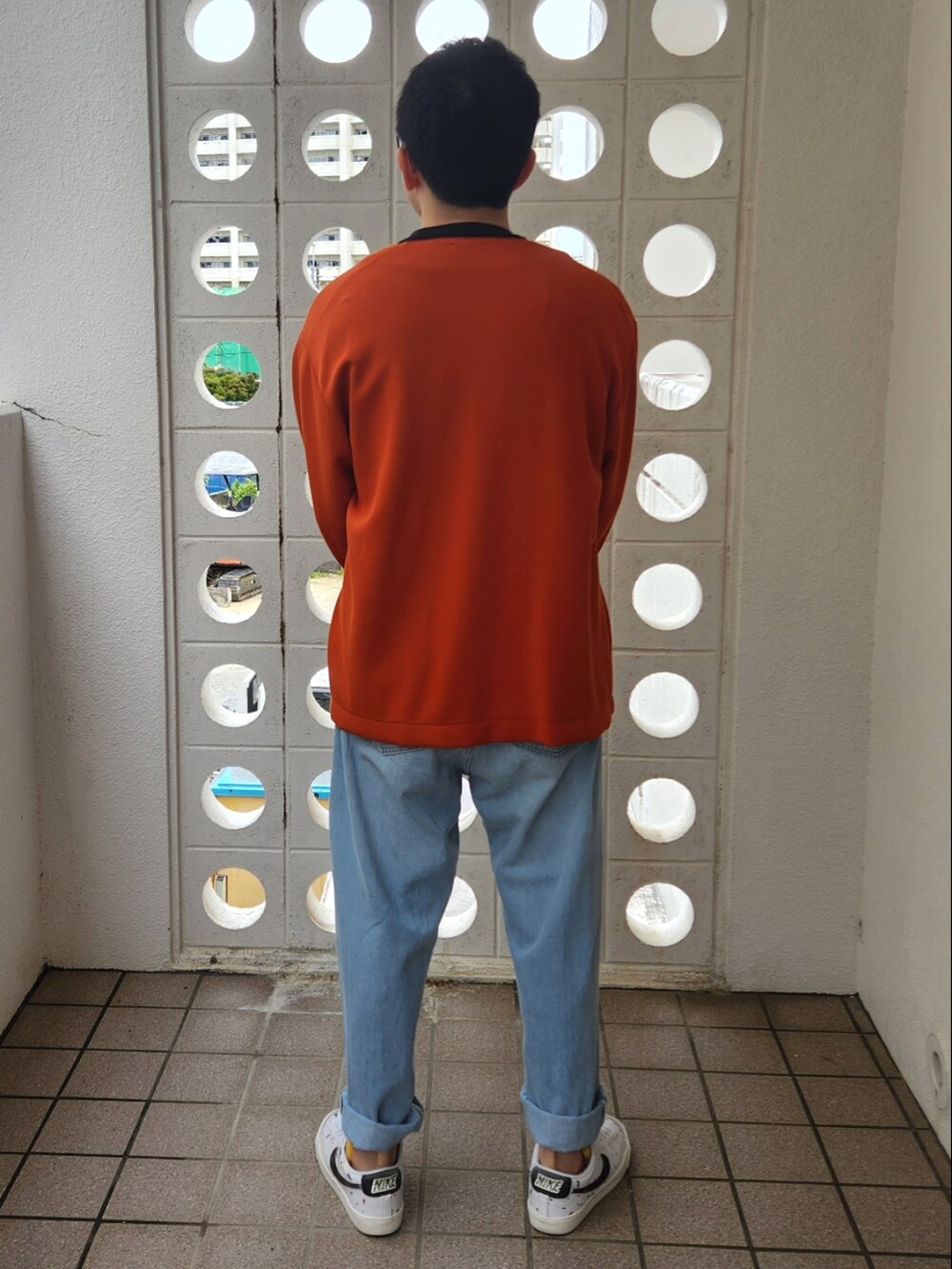 ブルー系のデニムパンツ、ホワイト系のスニーカー、ブラック系のTシャツ/カットソーを着用したメンズの春コーディネートの2枚目の写真