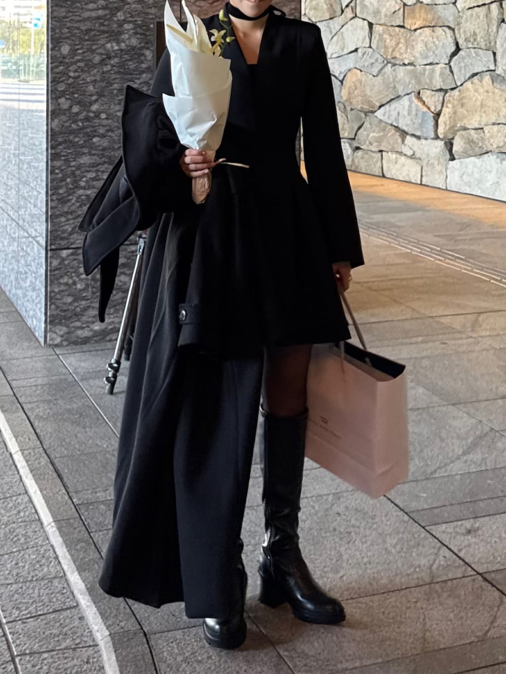 ブラック系のワンピース、ブラック系のブーツを着用したレディースの秋コーディネートの2枚目の写真