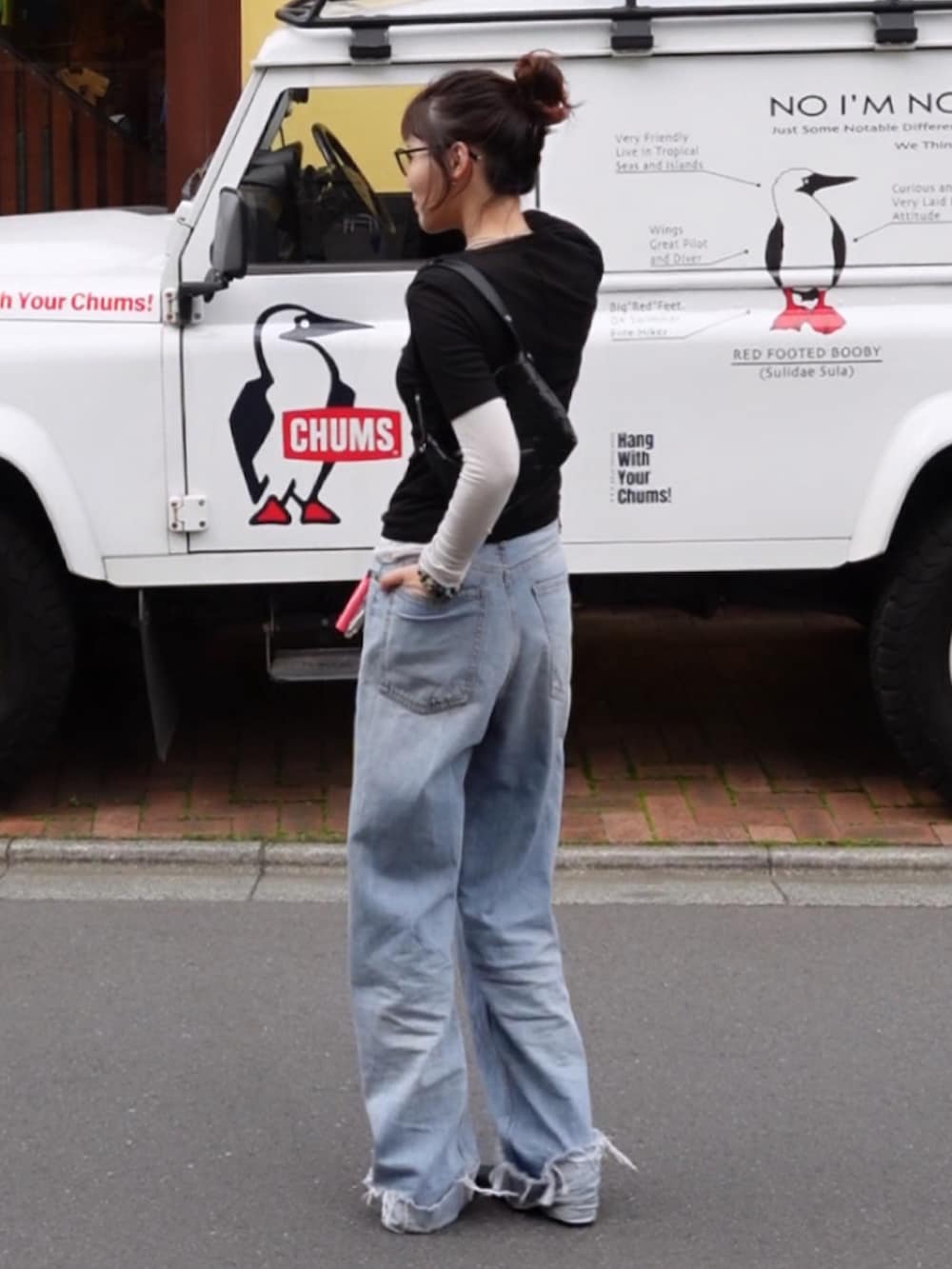 ブルー系のデニムパンツ、ブラック系のTシャツ/カットソー、ブラック系のブーツを着用したレディースの春コーディネートの2枚目の写真