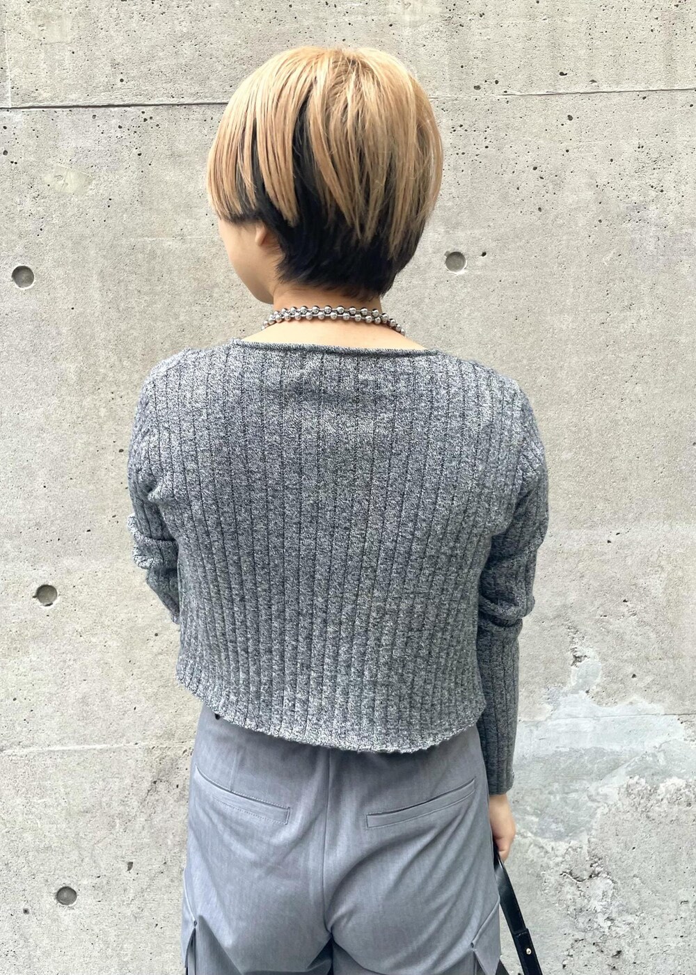 ブラック系のスニーカー、グレー系のカーゴパンツ、ブラック系のニット/セーターを着用したレディースの冬コーディネートの5枚目の写真