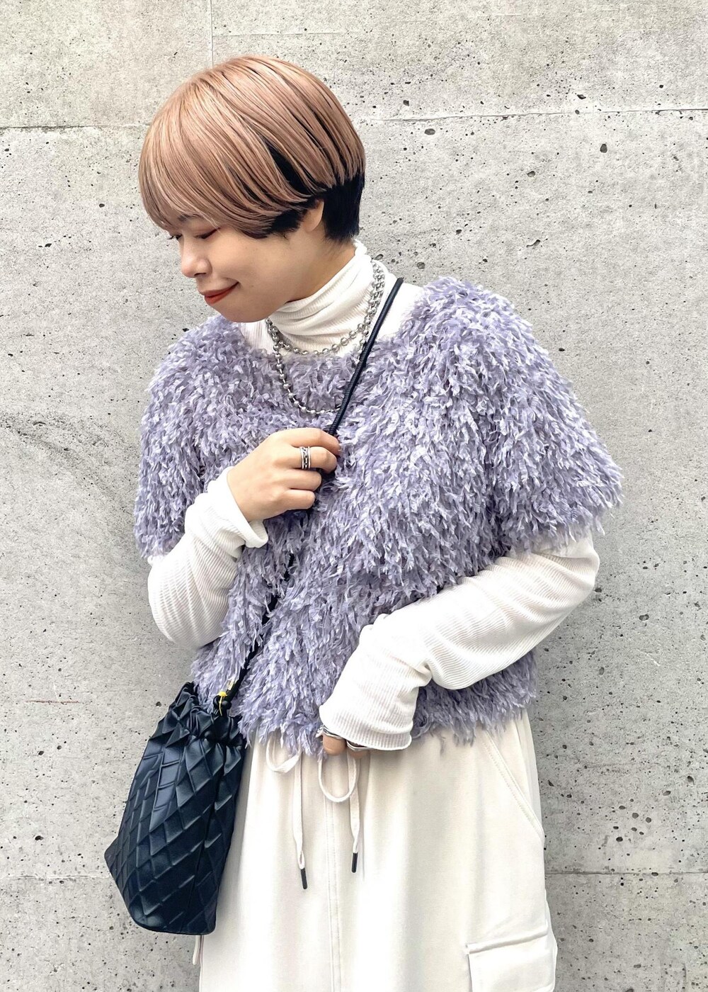 ホワイト系のTシャツ/カットソー、ベージュ系のスカート、ブラック系のスニーカーを着用したレディースの冬コーディネートの4枚目の写真