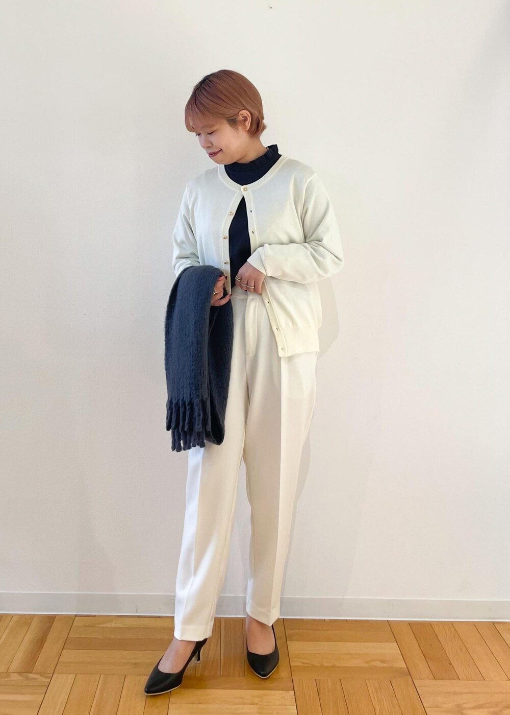 ホワイト系のカーディガン/ボレロ、ブラック系のパンプス、グレー系のシャツ/ブラウスを着用したレディースの冬コーディネートの2枚目の写真