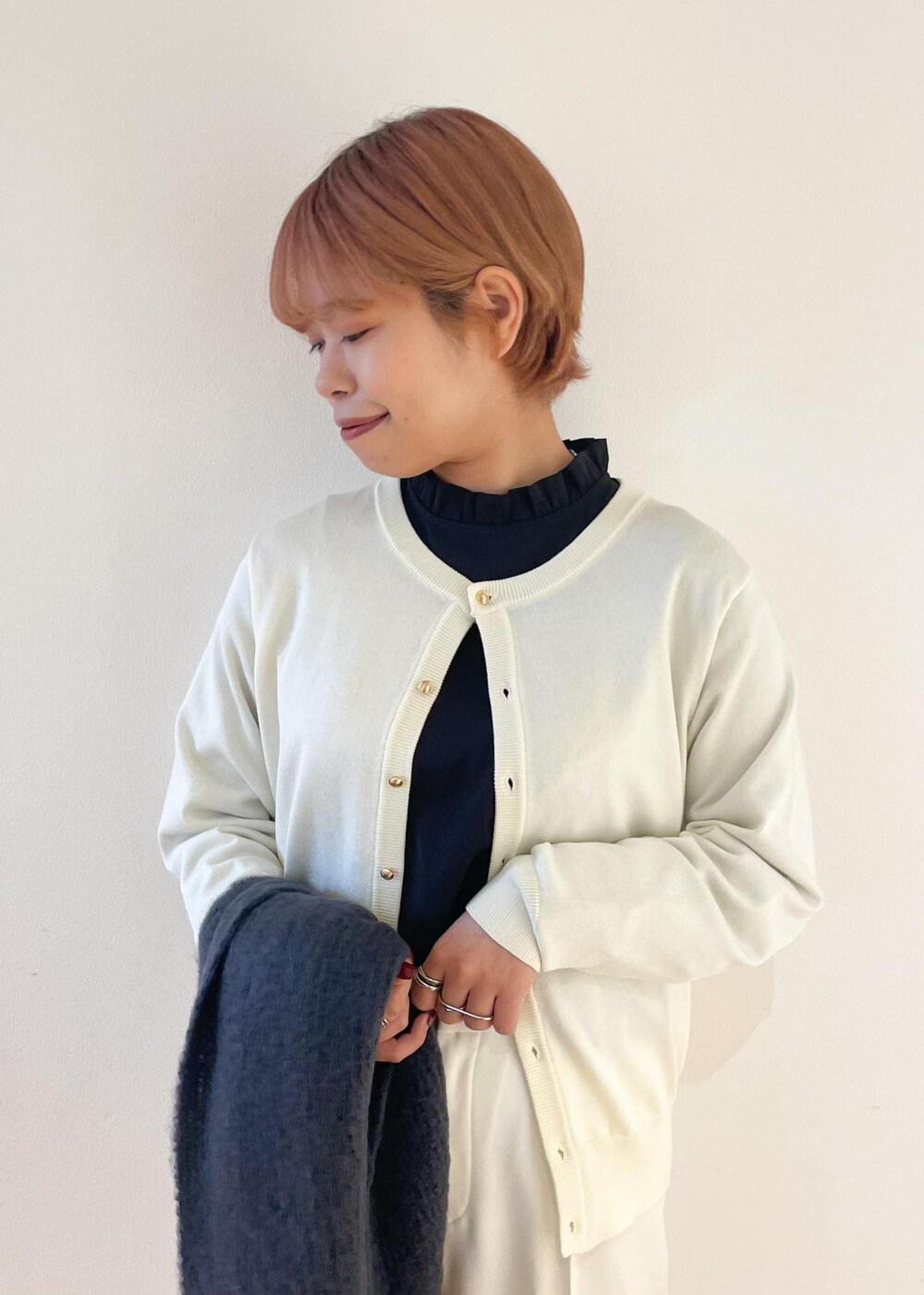 ホワイト系のカーディガン/ボレロ、ブラック系のパンプス、グレー系のシャツ/ブラウスを着用したレディースの冬コーディネートの4枚目の写真