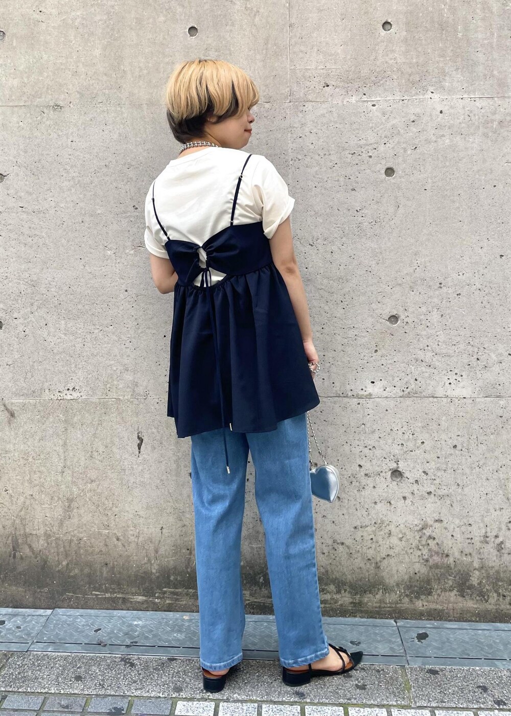 シルバー系のショルダーバッグ、ホワイト系のTシャツ/カットソー、ブルー系のキャミソールを着用したレディースの春コーディネートの3枚目の写真