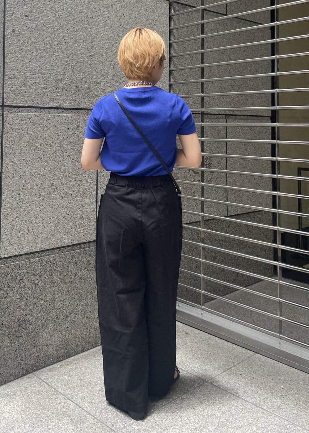 ブラック系のその他パンツ、ブラック系のショルダーバッグ、ブルー系のニット/セーターを着用したレディースの夏コーディネートの3枚目の写真