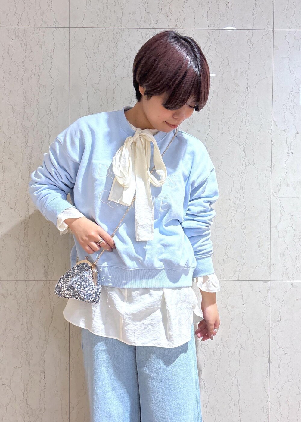 ブルー系のデニムパンツ、ブラック系のブーツ、グレー系のショルダーバッグを着用したレディースの冬コーディネートの5枚目の写真