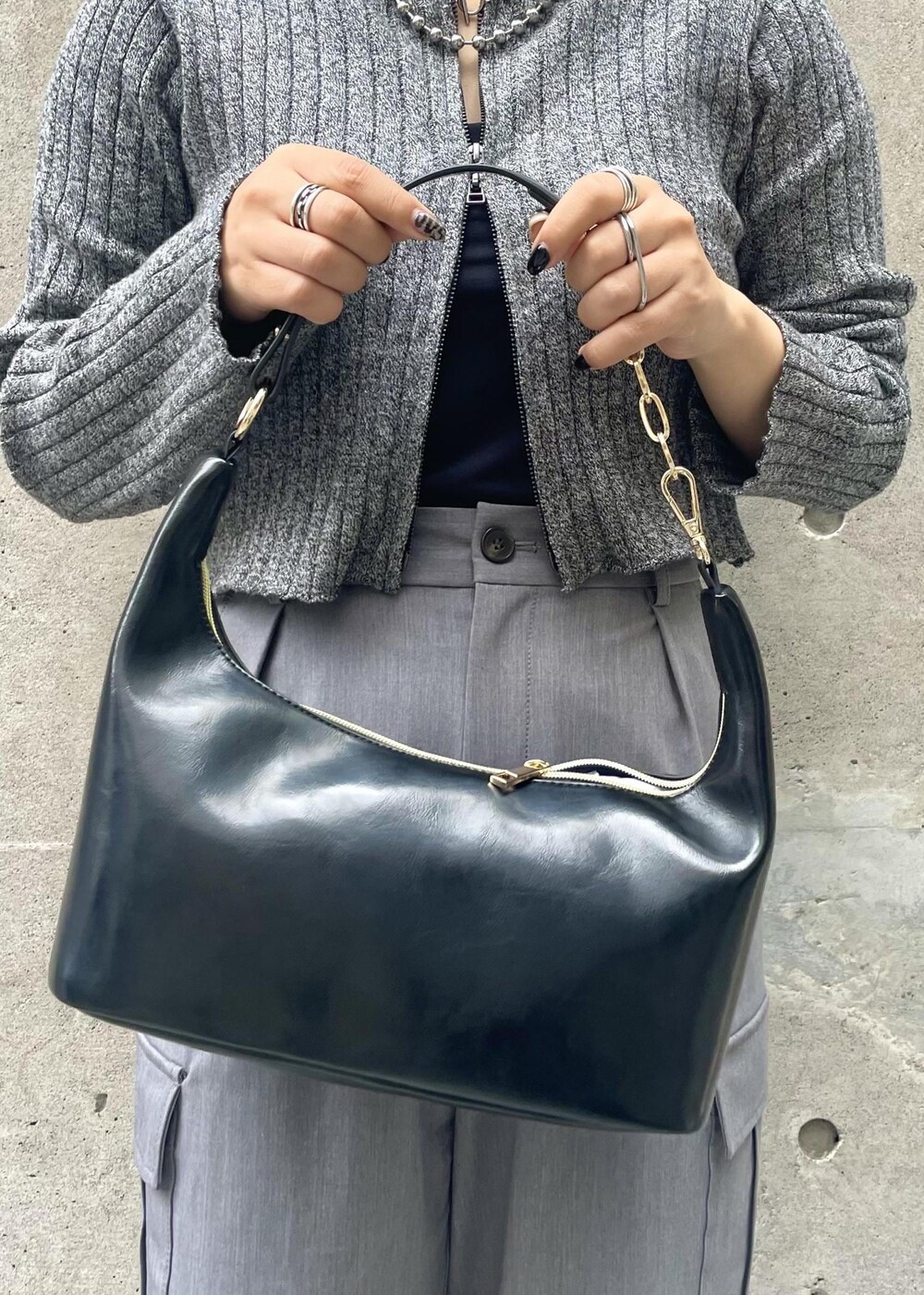 ブラック系のスニーカー、グレー系のカーゴパンツ、ブラック系のニット/セーターを着用したレディースの冬コーディネートの6枚目の写真