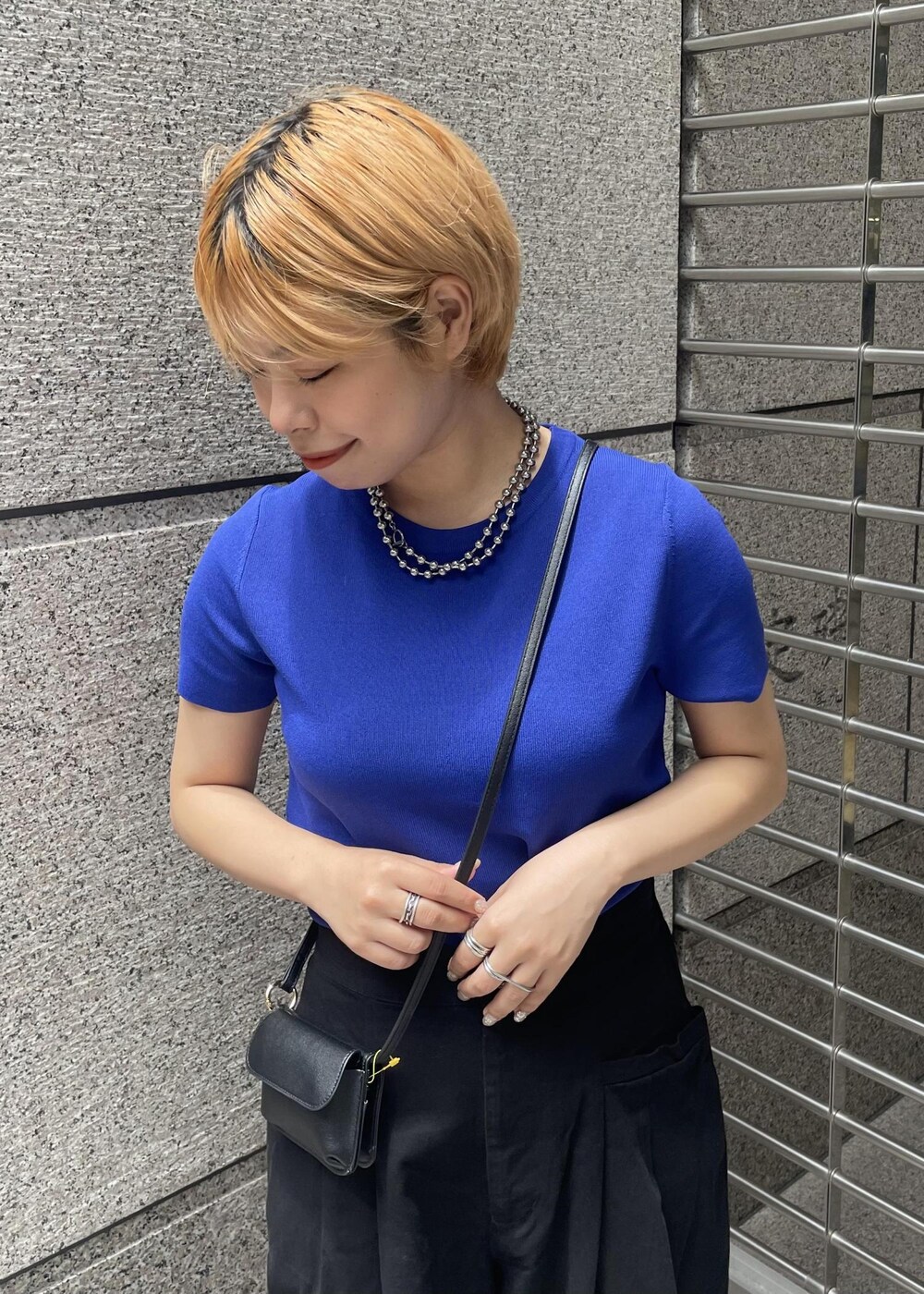 ブラック系のその他パンツ、ブラック系のショルダーバッグ、ブルー系のニット/セーターを着用したレディースの夏コーディネートの4枚目の写真