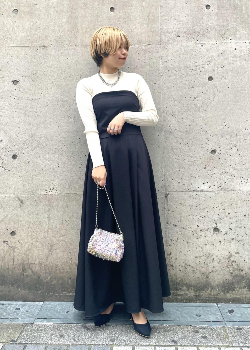 ブラック系のパンプス、ブラック系のワンピース、グレー系のショルダーバッグを着用したレディースの春コーディネートの2枚目の写真