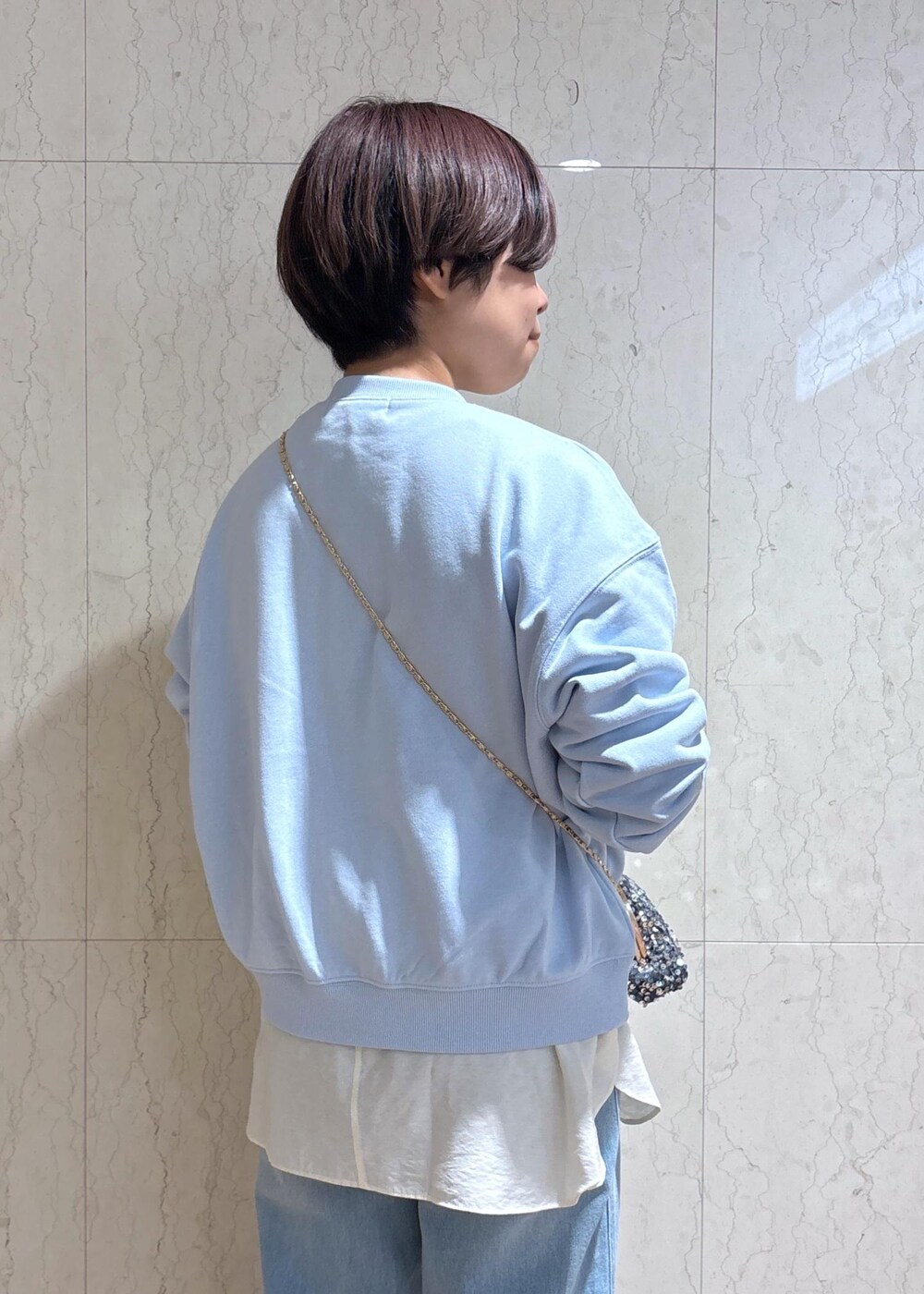 ブルー系のデニムパンツ、ブラック系のブーツ、グレー系のショルダーバッグを着用したレディースの冬コーディネートの6枚目の写真