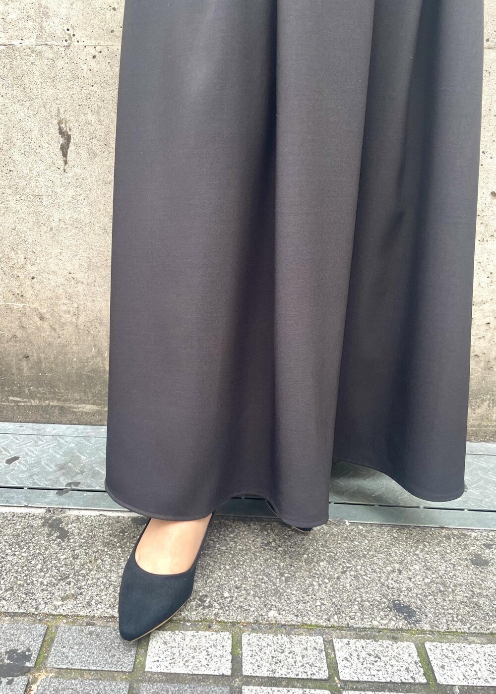 ブラック系のパンプス、ブラック系のワンピース、グレー系のショルダーバッグを着用したレディースの春コーディネートの7枚目の写真