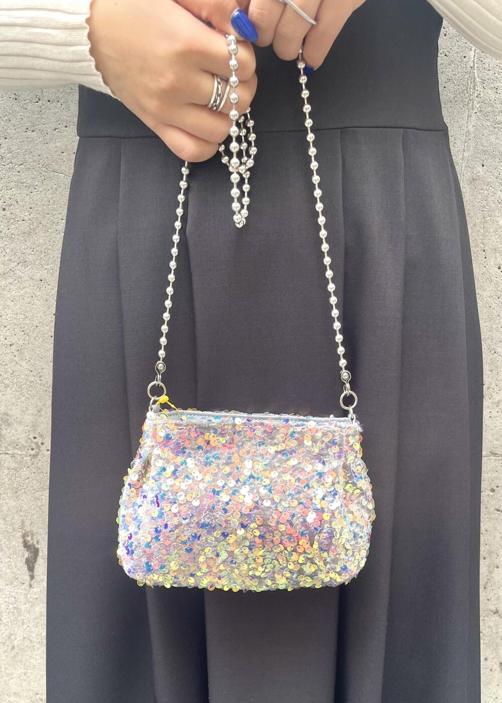 ブラック系のパンプス、ブラック系のワンピース、グレー系のショルダーバッグを着用したレディースの春コーディネートの6枚目の写真