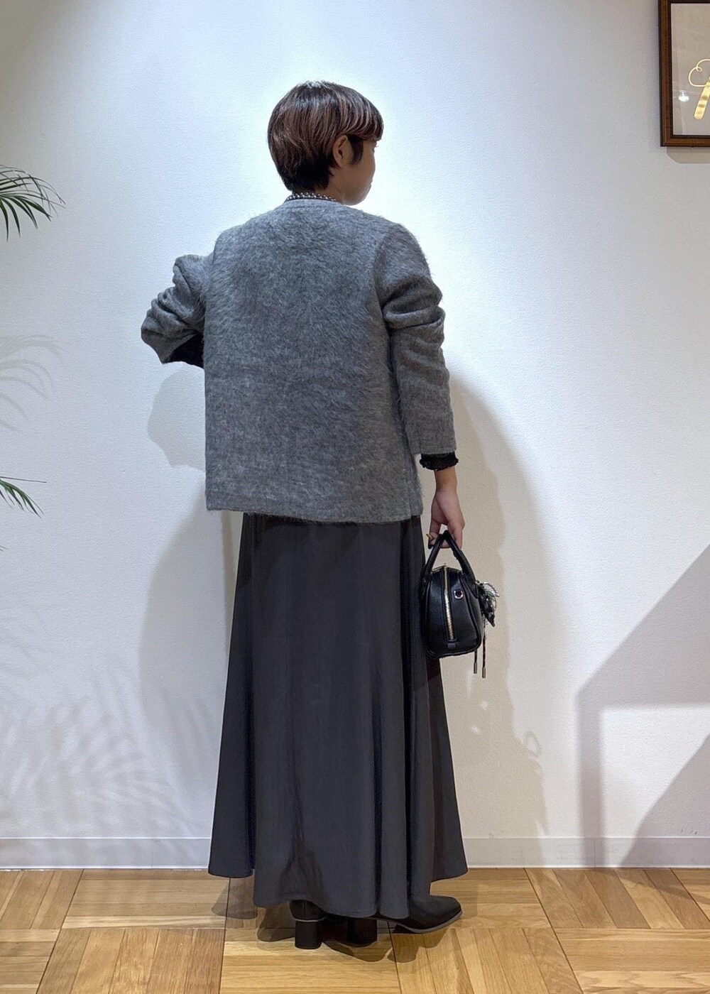 ブラック系のTシャツ/カットソー、グレー系のスカート、グレー系のカーディガン/ボレロを着用したレディースの秋コーディネートの5枚目の写真