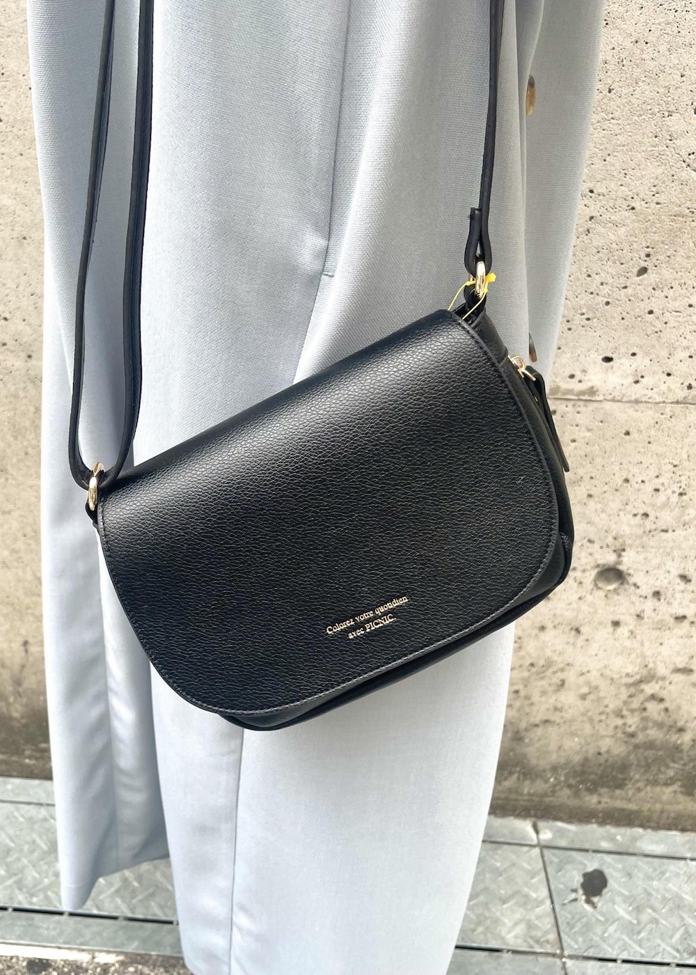 ブラック系のパンプス、ブラック系のショルダーバッグ、ブルー系のジャンパースカートを着用したレディースの春コーディネートの5枚目の写真