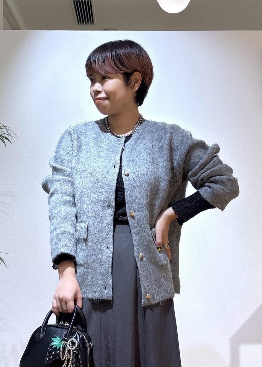 ブラック系のTシャツ/カットソー、グレー系のスカート、グレー系のカーディガン/ボレロを着用したレディースの秋コーディネートの6枚目の写真