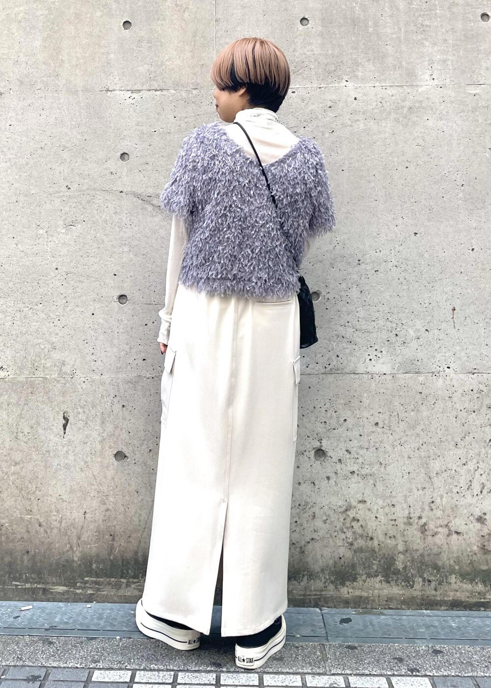 ホワイト系のTシャツ/カットソー、ベージュ系のスカート、ブラック系のスニーカーを着用したレディースの冬コーディネートの3枚目の写真