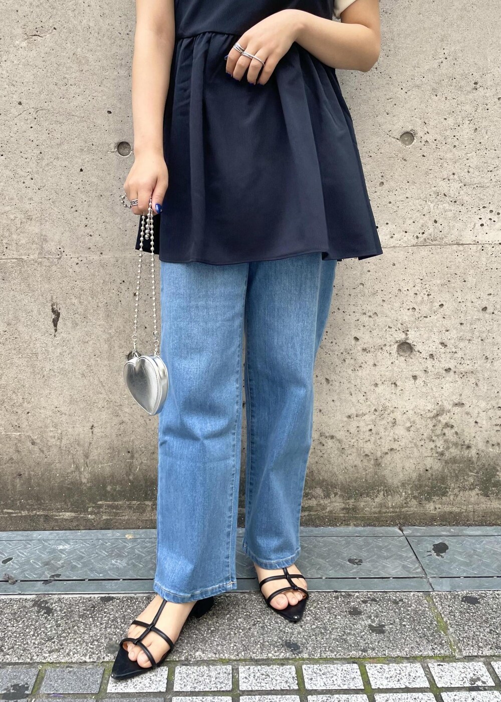 シルバー系のショルダーバッグ、ホワイト系のTシャツ/カットソー、ブルー系のキャミソールを着用したレディースの春コーディネートの6枚目の写真