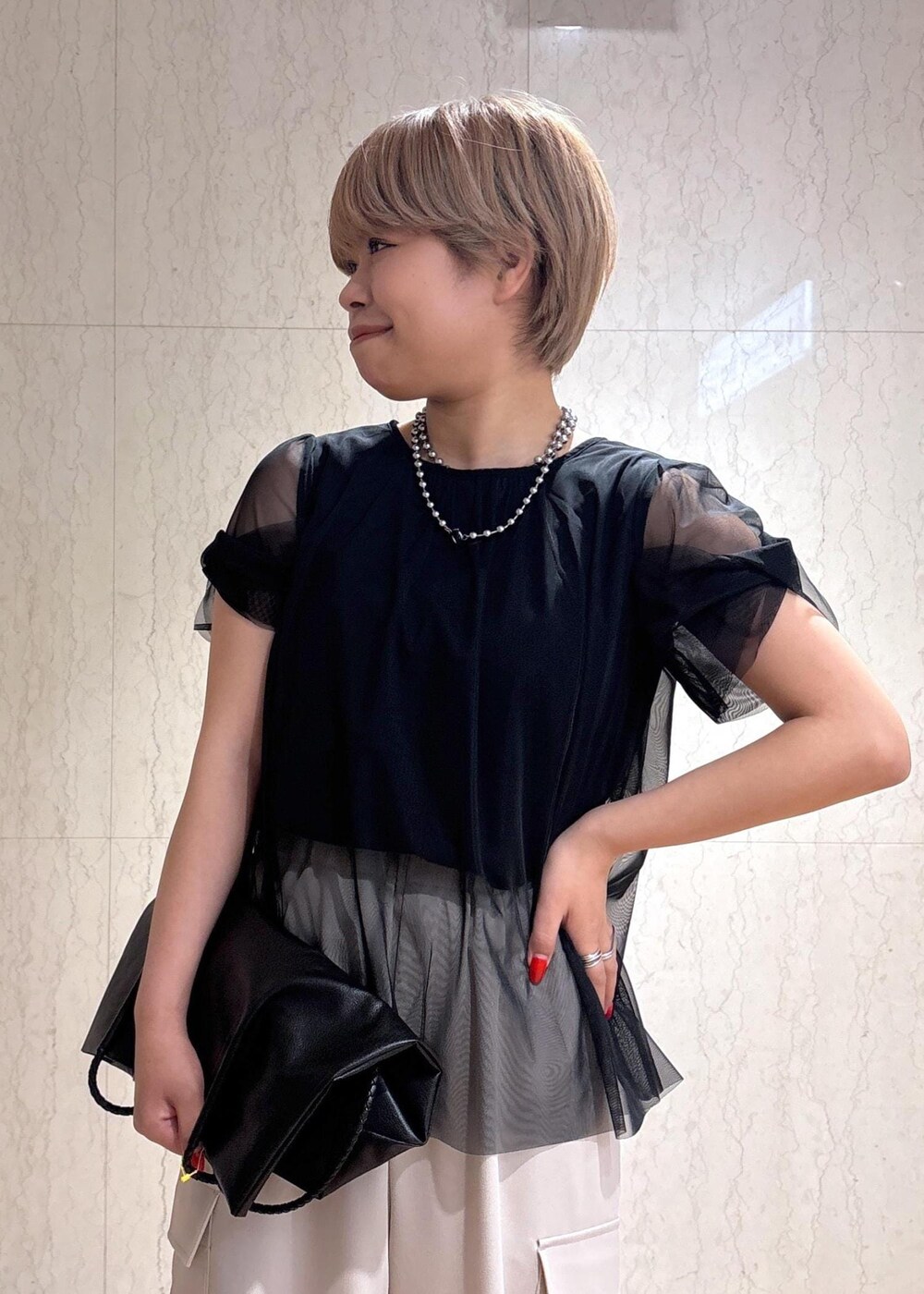 ブラック系のトートバッグ、ベージュ系のカーゴパンツ、ブラック系のTシャツ/カットソーを着用したレディースの春コーディネートの5枚目の写真