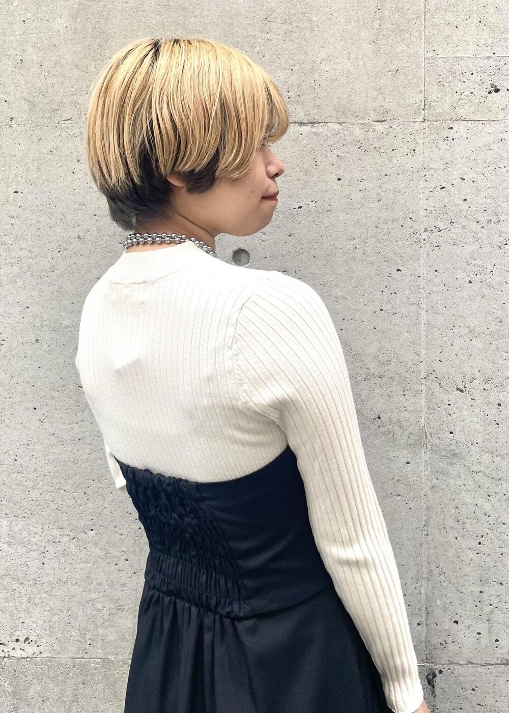 ブラック系のパンプス、ブラック系のワンピース、グレー系のショルダーバッグを着用したレディースの春コーディネートの5枚目の写真