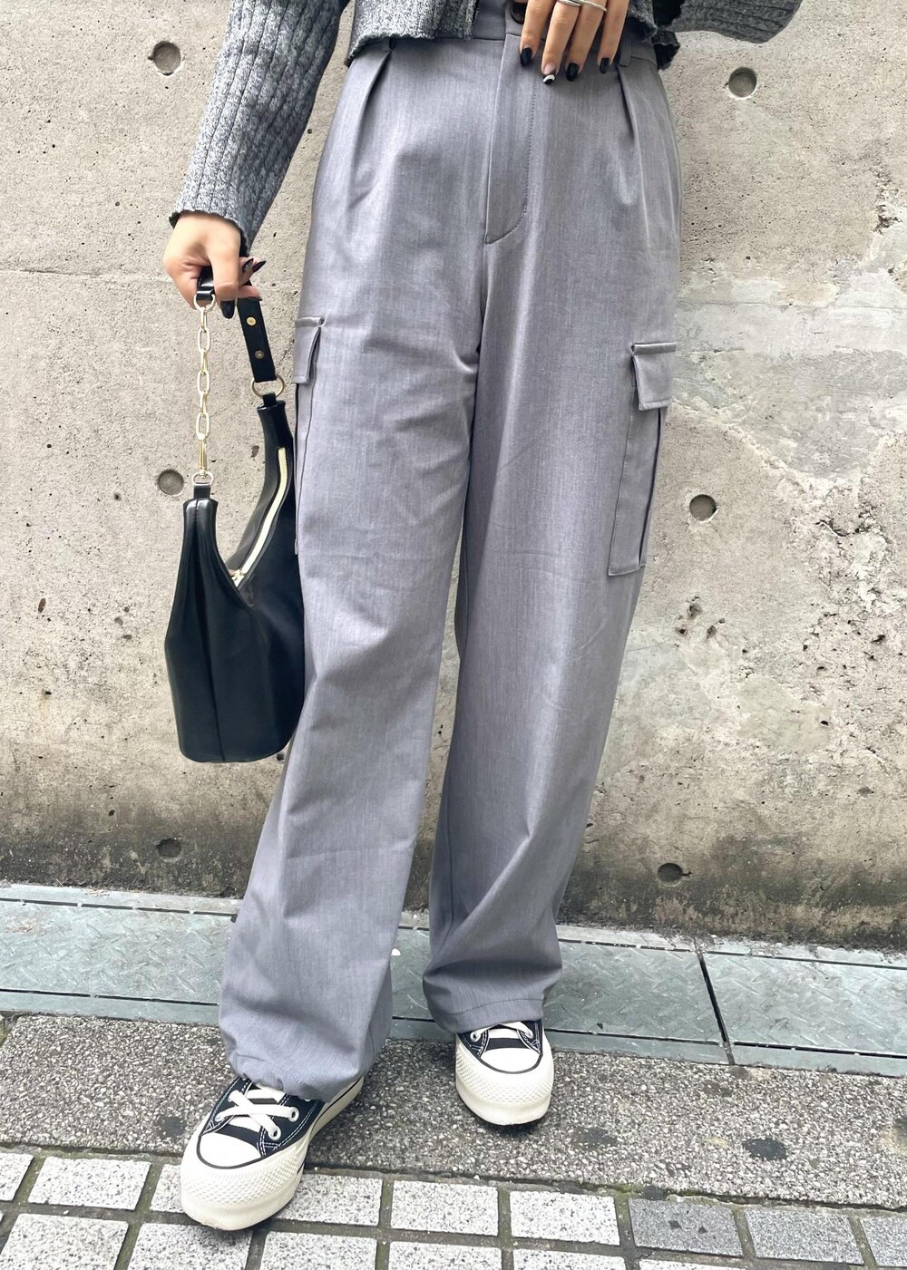 ブラック系のスニーカー、グレー系のカーゴパンツ、ブラック系のニット/セーターを着用したレディースの冬コーディネートの7枚目の写真