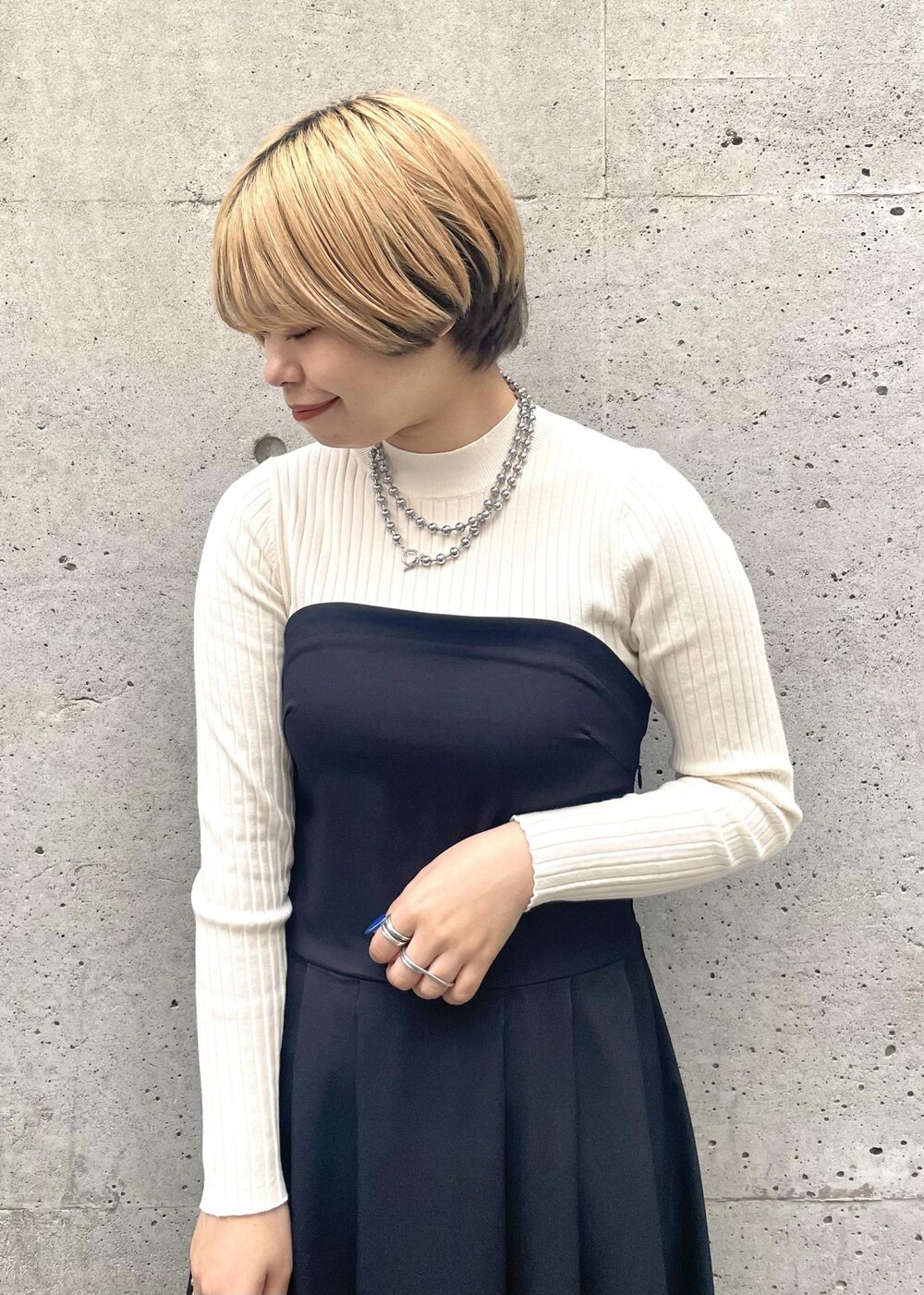 ブラック系のパンプス、ブラック系のワンピース、グレー系のショルダーバッグを着用したレディースの春コーディネートの4枚目の写真