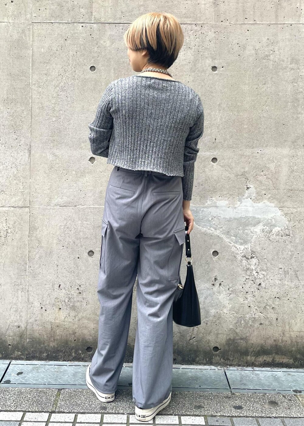 ブラック系のスニーカー、グレー系のカーゴパンツ、ブラック系のニット/セーターを着用したレディースの冬コーディネートの3枚目の写真