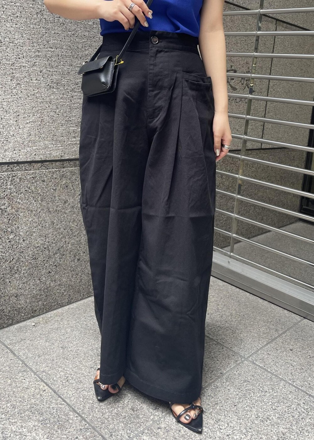 ブラック系のその他パンツ、ブラック系のショルダーバッグ、ブルー系のニット/セーターを着用したレディースの夏コーディネートの6枚目の写真