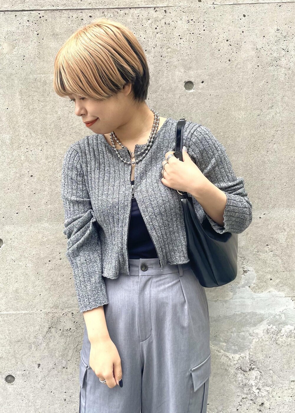 ブラック系のスニーカー、グレー系のカーゴパンツ、ブラック系のニット/セーターを着用したレディースの冬コーディネートの4枚目の写真